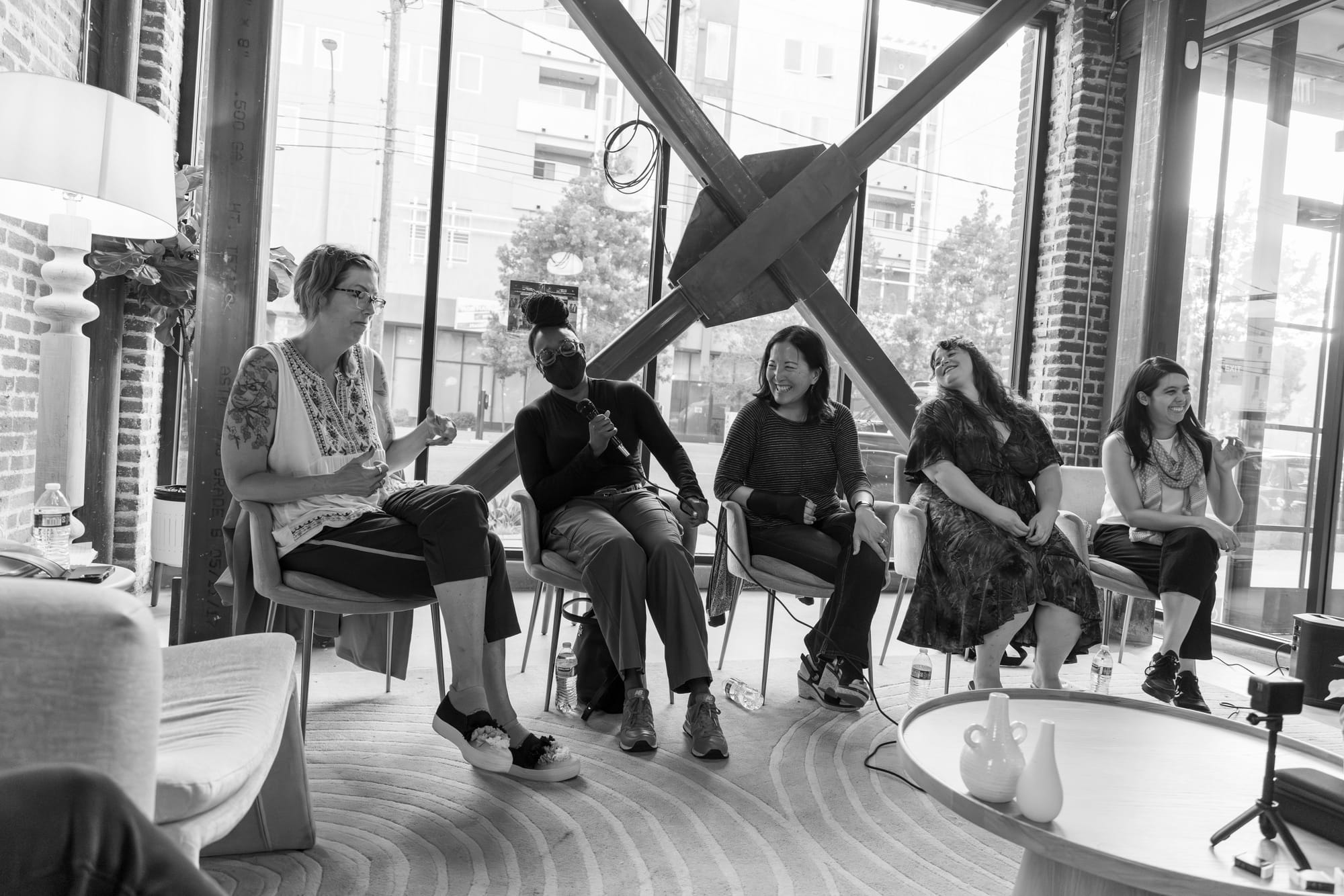 The five women on the Burn It Down panel all laugh and smile in a black and white photo.