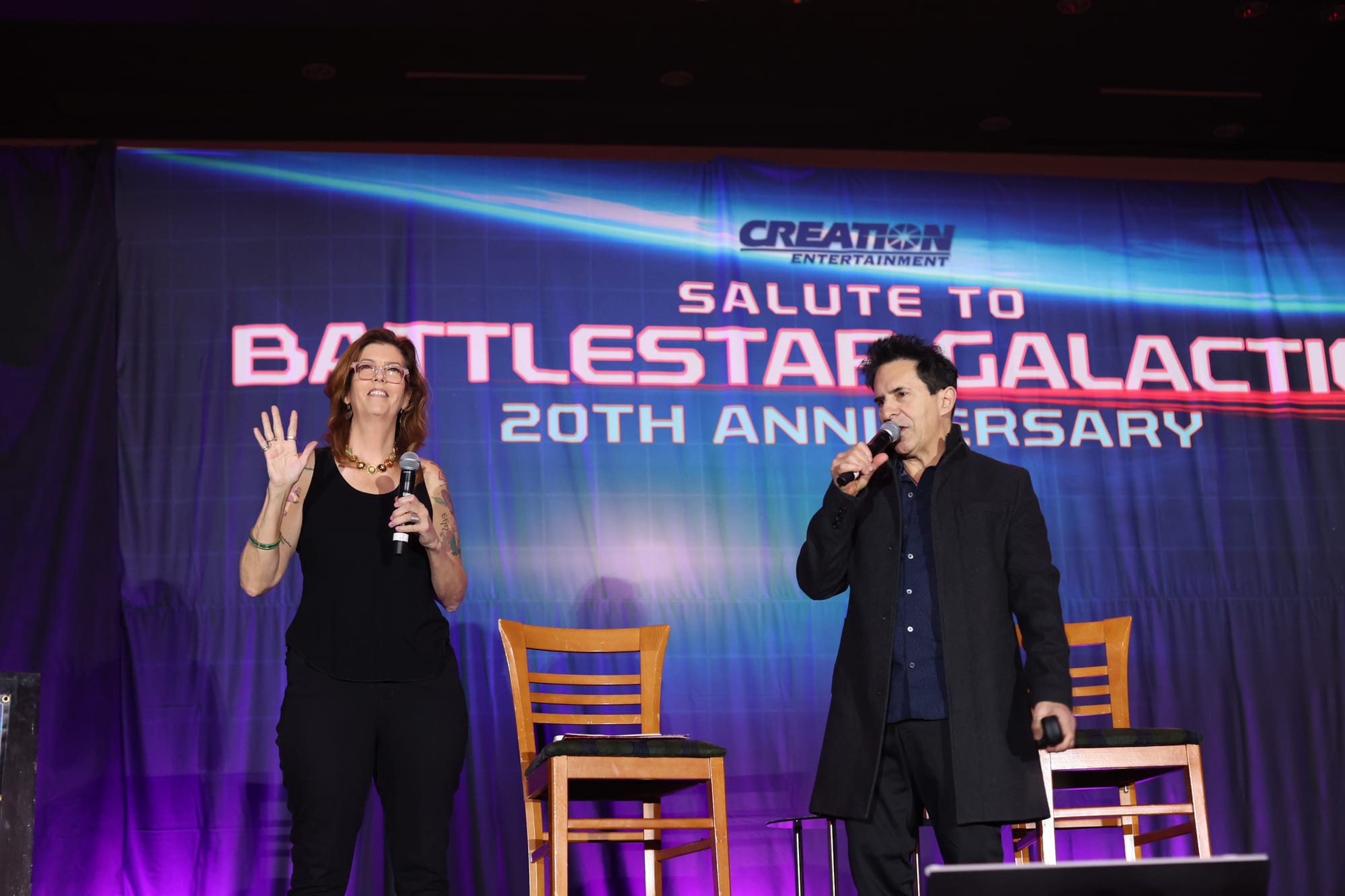 Maureen Ryan and Adam Malin, both wearing black, against a blue and purple backdrop that says Creation Salute to Battlestar Galactica