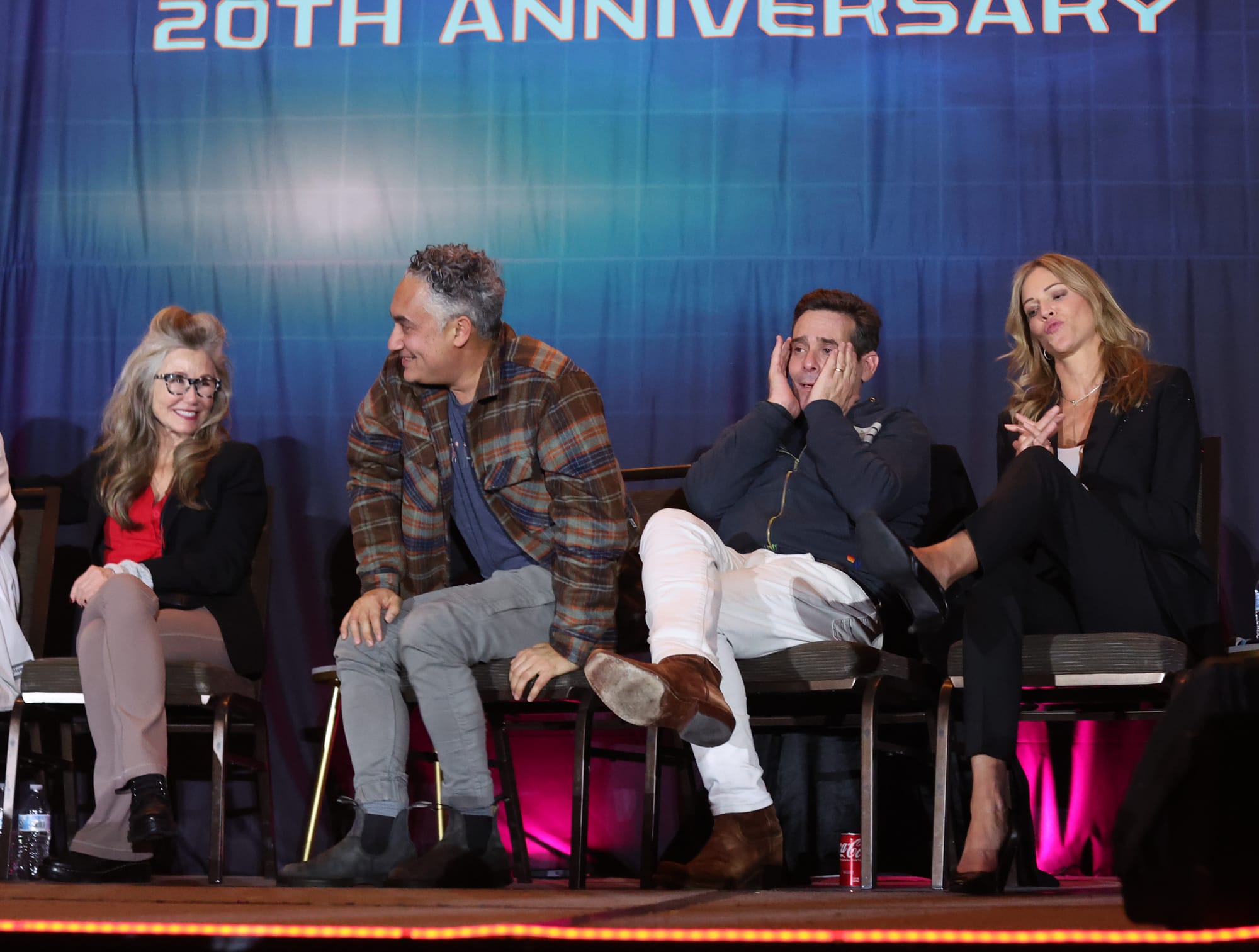 Four actors seated on a stage against a blue backdrop: Mary McDonnell, Alessandro Juliani, James Callis and Tricia Helfer