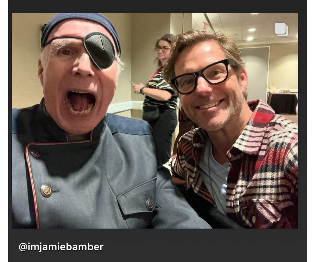 Michael Hogan and Jamie Bamber in a hallway at the BSG con. Hogan is mid-yell and Bamber is smiling.